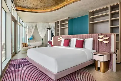 a bedroom with a large white bed with red pillows at W Dubai - Mina Seyahi in Dubai