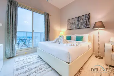 a bedroom with a large bed and a large window at Serene Studio in Elite Residences 4 Sports City by Deluxe Holiday Homes in Dubai
