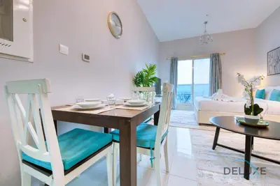 a dining room and living room with a table and chairs at Serene Studio in Elite Residences 4 Sports City by Deluxe Holiday Homes in Dubai