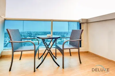 a table and chairs in a room with a view at Serene Studio in Elite Residences 4 Sports City by Deluxe Holiday Homes in Dubai