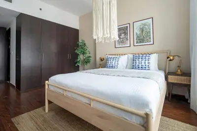 a bedroom with a large bed with blue and white pillows at Frank Porter - The Point in Dubai