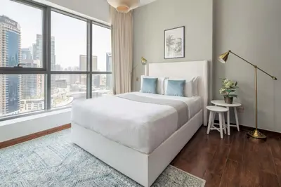 a bedroom with a white bed and a large window at Frank Porter - The Point in Dubai