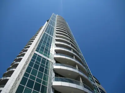 a tall building with glass windows and a blue sky at Frank Porter - The Point in Dubai