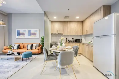 a kitchen and living room with a table and chairs at Charming 2BR at Rawda Parkview Town Square Dubailand by Deluxe Holiday Homes in Dubai