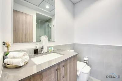 a bathroom with a sink and a toilet and a mirror at Charming 2BR at Rawda Parkview Town Square Dubailand by Deluxe Holiday Homes in Dubai