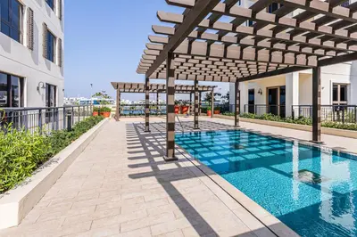 a swimming pool with a pergola next to a building at Lovely sea view apt La Cote 1 La Mer 1min to beach in Dubai