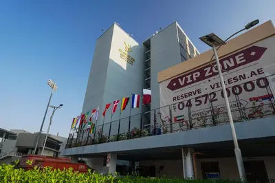 a building with a bunch of flags on it at Emirates Sports Hotel, Dubai Sports City in Dubai