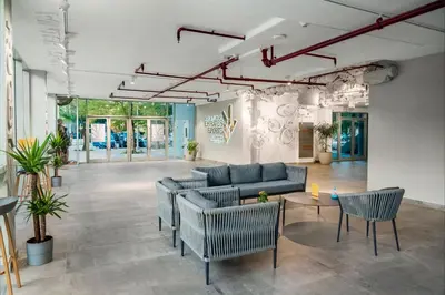 a lobby with couches and chairs in a building at Emirates Sports Hotel, Dubai Sports City in Dubai