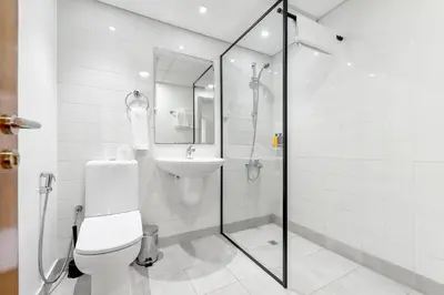 a bathroom with a toilet and a sink at Emirates Sports Hotel, Dubai Sports City in Dubai