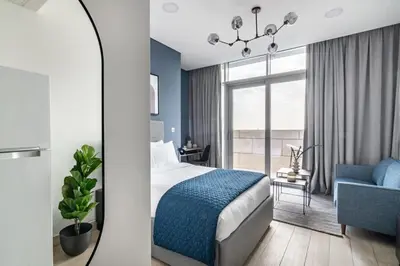 a bedroom with a bed and a chair and a window at Silkhaus comfy DIFC studio with Burj Khalifa view in Dubai
