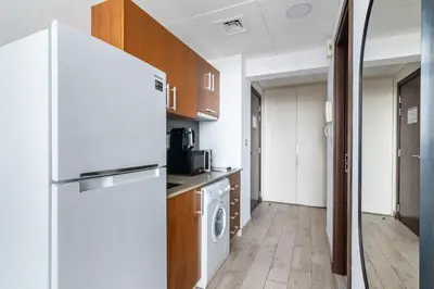 a kitchen with a refrigerator and a washer and dryer at Silkhaus comfy DIFC studio with Burj Khalifa view in Dubai