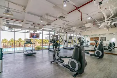 a gym with treadmills and elliptical machines at Silkhaus comfy DIFC studio with Burj Khalifa view in Dubai