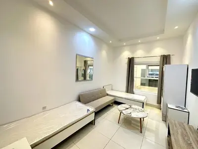 a living room with a couch and a table at Economical Rooms for rent in Dubai in Dubai