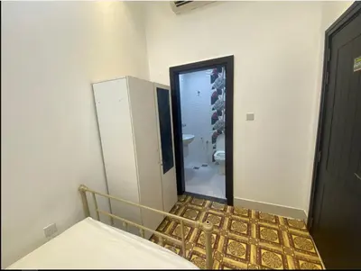a room with a bed and a bathroom with a mirror at Economical Rooms for rent in Dubai in Dubai