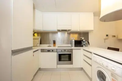 a kitchen with white cabinets and a microwave at Emaar Fashion Avenue - Formerly Address Dubai Mall Four Apple in Dubai