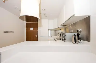 a kitchen with white counters and a white counter top at Emaar Fashion Avenue - Formerly Address Dubai Mall Four Apple in Dubai