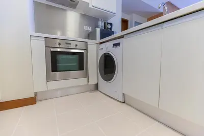 a kitchen with a washing machine and a washer at Emaar Fashion Avenue - Formerly Address Dubai Mall Four Apple in Dubai