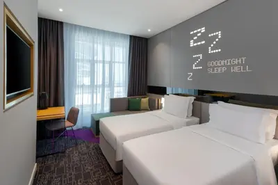 a hotel room with two beds and a couch at Studio M Al Barsha Hotel by Millennium in Dubai