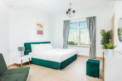 a white bedroom with a bed and a window at Dreamy and Spacious 3BR Unique Palm Jumeirah in Dubai