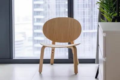 a wooden chair sitting in front of a window at Spacious & Full of light 3BR+ kids Dubai Mall in Dubai