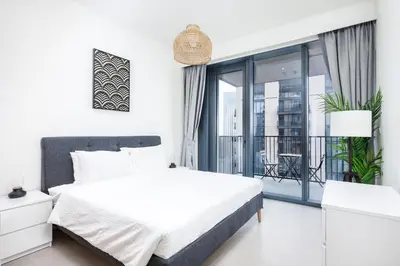 a white bedroom with a bed and a balcony at Spacious & Full of light 3BR+ kids Dubai Mall in Dubai