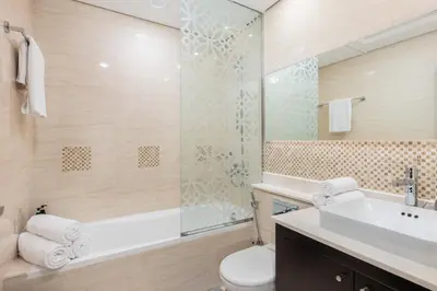 a bathroom with a toilet and a sink and a shower at Lovely & Pristine 2BR + kids - 7min to Dubai Mall in Dubai