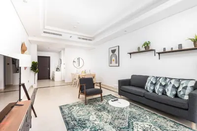 a living room with a couch and a table at Lovely & Pristine 2BR + kids - 7min to Dubai Mall in Dubai