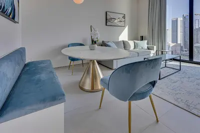 a living room with a table and a couch at Stylish 1BD apartment in Address Beach Residence in Dubai