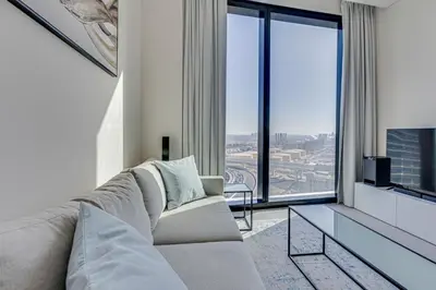 a living room with a couch and a large window at Stylish 1BD apartment in Address Beach Residence in Dubai