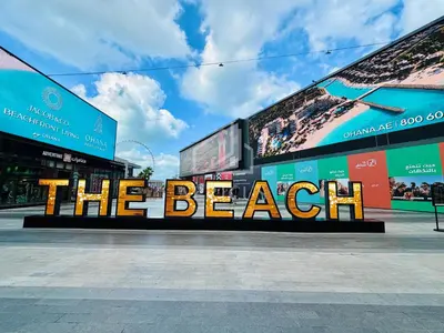 a sign that says the beach in front of a building at Stylish 1BD apartment in Address Beach Residence in Dubai