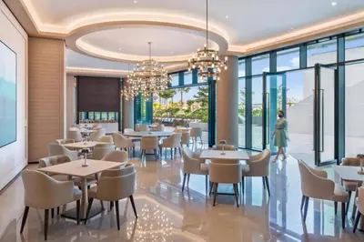 a dining room with tables and chairs and windows at 2 BDR Apt The Address Beach Resort JBR in Dubai