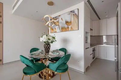 a dining room with a glass table and green chairs at 2 BDR Apt The Address Beach Resort JBR in Dubai