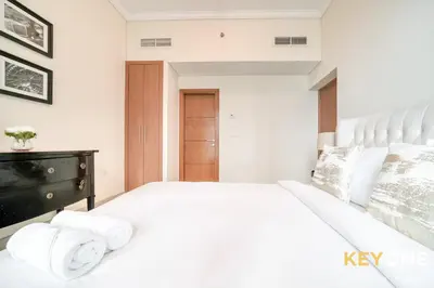 a white bedroom with a large bed with towels on it at Captivating Sky & Sea Views in Two Bedroom Suite in Dubai