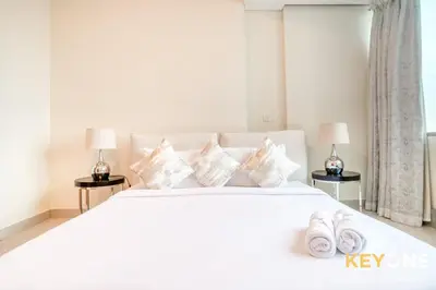 a bedroom with a white bed with two lamps and two slippers at Captivating Sky & Sea Views in Two Bedroom Suite in Dubai
