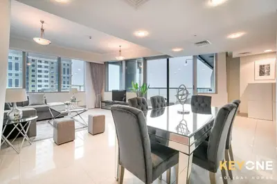 a dining room and living room with a glass table and chairs at Captivating Sky & Sea Views in Two Bedroom Suite in Dubai