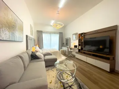 a living room with a couch and a tv at Luxury Studio Apartment Close to JBR Beach&Yacht Club&Metro-Available Airport Shuttle in Dubai