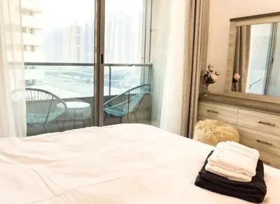 a bedroom with a bed and a balcony at Luxury Studio Apartment Close to JBR Beach&Yacht Club&Metro-Available Airport Shuttle in Dubai