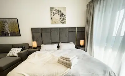 a bedroom with a large white bed and a couch at Luxury Studio Apartment Close to JBR Beach&Yacht Club&Metro-Available Airport Shuttle in Dubai