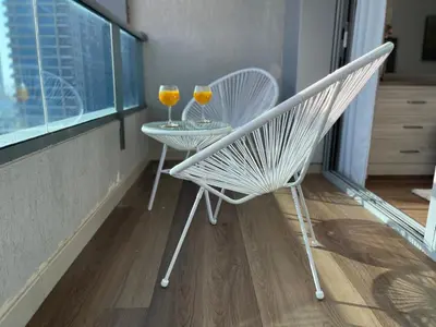two glasses of wine sitting on a table on a balcony at Luxury Studio Apartment Close to JBR Beach&Yacht Club&Metro-Available Airport Shuttle in Dubai