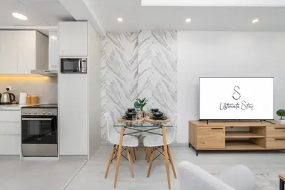 a kitchen with a table and a tv on a wall at Modern 1BR with City View Rooftop Pool Access in Dubai