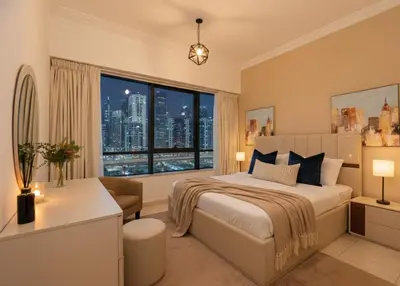 a bedroom with a bed and a large window at Modern 1BR with City View Rooftop Pool Access in Dubai