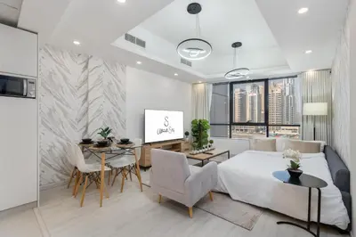 a bedroom with a bed and a table and chairs at Modern 1BR with City View Rooftop Pool Access in Dubai