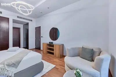 a bedroom with a bed and a couch and a chair at bnbme - Beachfront 1BR Palm Jumeirah Apt w Balcony Sea Views Pool & Beach Access in Dubai