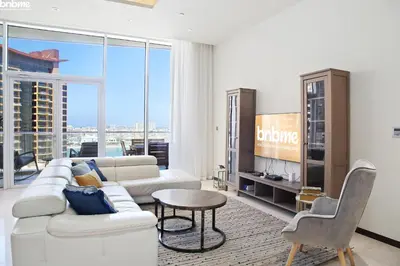 a living room with a white couch and a table at bnbme - Beachfront 1BR Palm Jumeirah Apt w Balcony Sea Views Pool & Beach Access in Dubai