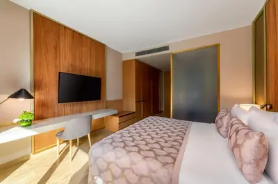 a hotel room with a bed and a desk and a tv at Voco Dubai Monaco, The Heart of Europe by IHG-Adult only in Dubai