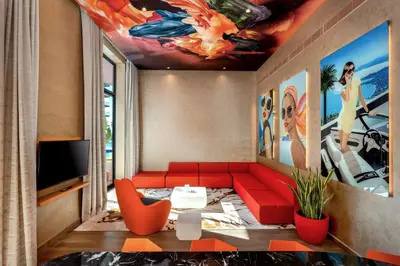 a living room with a red couch and a tv at Voco Dubai Monaco, The Heart of Europe by IHG-Adult only in Dubai