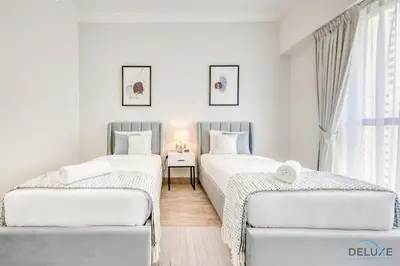 two twin beds in a room with a window at Spacious 3BR Apartment with Assistant Room in Sadaf 5 JBR by Deluxe Holiday Homes in Dubai