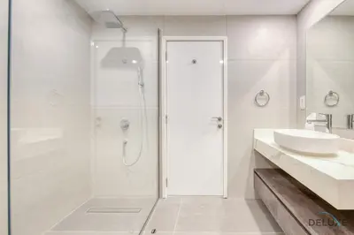 a white bathroom with a shower and a sink at Spacious 3BR Apartment with Assistant Room in Sadaf 5 JBR by Deluxe Holiday Homes in Dubai
