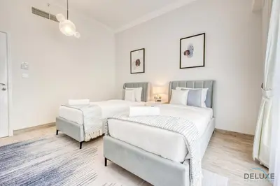 a bedroom with two beds and a chair at Spacious 3BR Apartment with Assistant Room in Sadaf 5 JBR by Deluxe Holiday Homes in Dubai