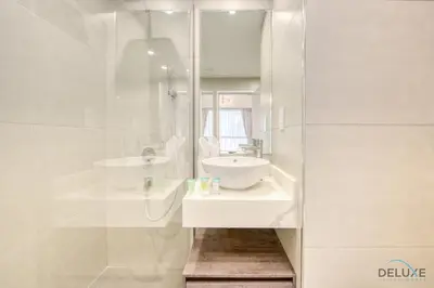 a white bathroom with a sink and a mirror at Spacious 3BR Apartment with Assistant Room in Sadaf 5 JBR by Deluxe Holiday Homes in Dubai